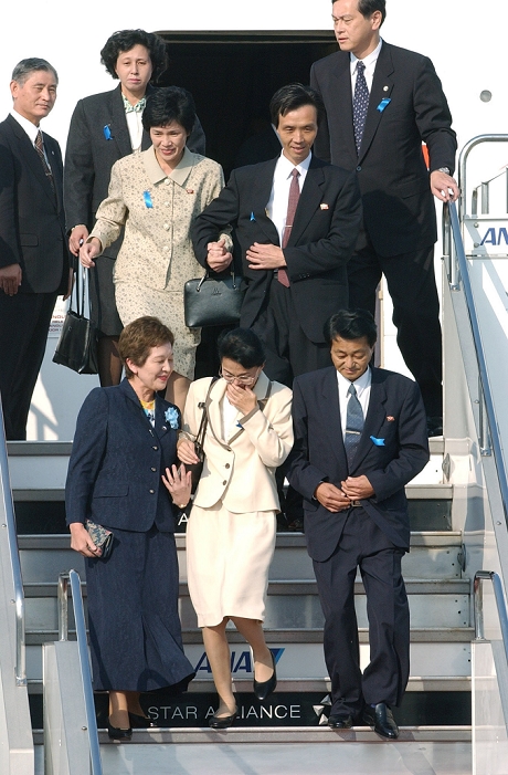 Five victims of the North Korean abductions return home after 24 years and descend the ramp. Five victims of the abduction of Japanese citizens by North Korea descend the ramp after returning home from Pyongyang for the first time in 24 years. Yasushi Jimura  front right , Mrs. Tomikie  center  and her husband, Kaoru Hasuike  second row, right , Ms. Yukiko  left  and her husband, Hitomi Soga  back row, left . In the foreground, left, is Cabinet Counselor Kyoko Nakayama. Photo taken at Haneda Airport on October 15, 2002  published in the December 20, 2002 morning edition of  The 10 Greatest News in Japan as Selected by the Readers in 2002,  in  Years of Efforts Fulfilled.
