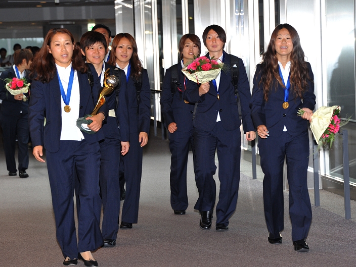 Nadeshiko Japan Makes Triumphant Return Thousands of people greeted at the airport July 19, 2011, Narita, Japan   Nozomi Yamago, left, proudly carries the World Cup trophy as Nadeshiko Japan s eleven makes the team Front row right with a bouquet of flower is the team s captain Homare S. Sasaki. Thousands of joyous, flag waving supporters greeted the team as the players arrived home after beating the United States in the Soccer World Cup. Thousands of joyous, flag waving supporters greeted the team as the players arrived home after beating the United States in the soccer World Cup final.  Photo by Natsuki Sakai AFLO   3615   mis 