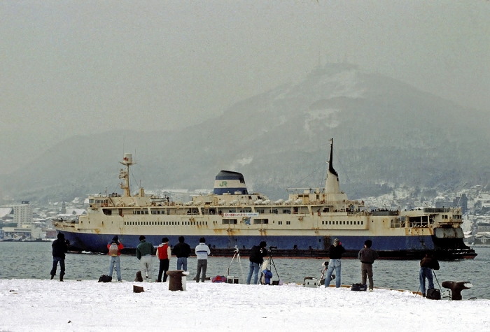 Seikan Kisen Ships, enthusiasts photographing the ships at Hakodate Port, 1988. A group of enthusiasts take photos of the Seikan Line at Hakodate Port. The  Queen of the Straits,  whose 80 year history has been marked by many romantic stories, will be replaced by a  strait train  that will run through the world s longest undersea tunnel. This photo was taken on March 12, 1988. Photo taken on March 12, 1988, published in the evening edition of the same day.