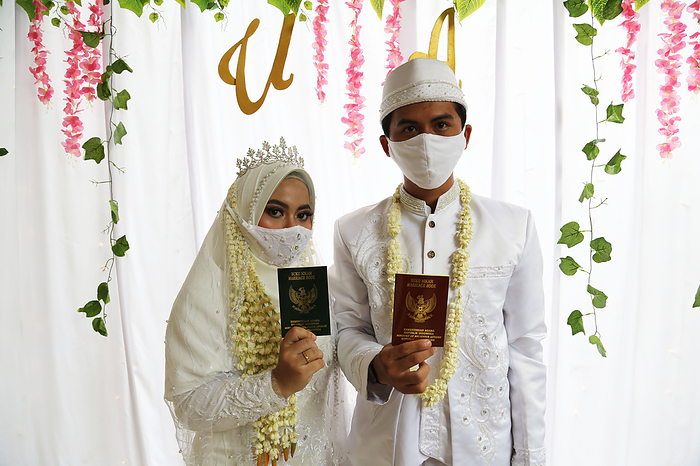 The Marriage Ceremony amid Coronavirus in Jakarta, Indonesia Bride Ulfa and groom Adul, wearing face masks as a precaution, during the marriage ceremony in Jakarta, Indonesia, July 4, 2020. The marriage ceremony was held inside a home with least number of people maintaining the guidelines of physical distancing.