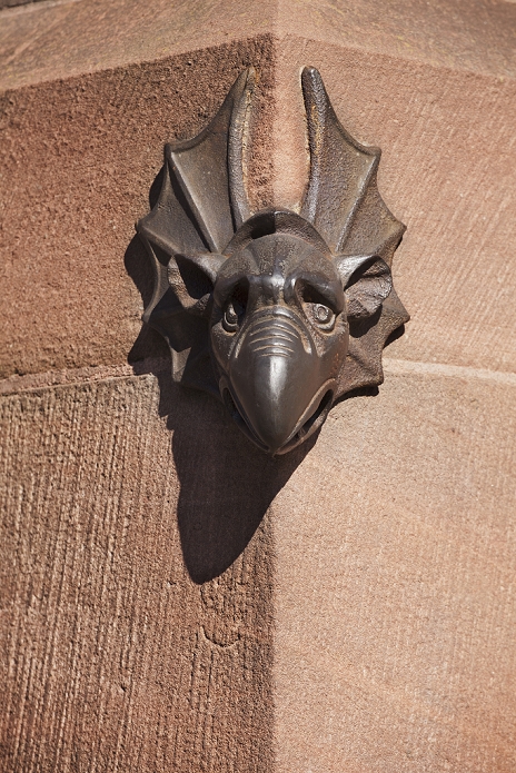 a sandstone beaked gargoyle face on a building's corner; strasbourg, france