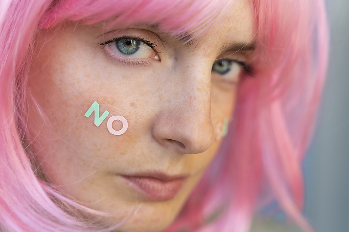 Barcelona, Spain, Young woman wearing pastel pop colorful funky look. Wig, pink, blue, pop, minimal, coloful, pastel, fun, funny, unique, different, colors, creative, pop, hairstyle, look, fashion Portrait of young woman wearing pink wig with word  no  on her cheek