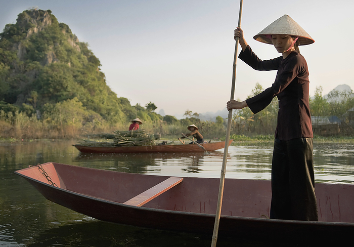 Woman Standing In Rowing Boat, Wearing Traditional Dress Photo by Elena Roman / Design Pics