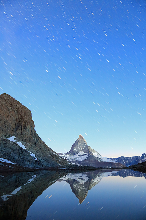 Star trails just before dawn at Riffelsee, Zermatt, Switzerland and the Matterhorn upside down