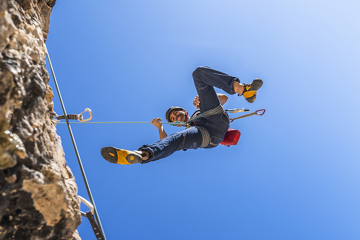 couple climbing outdoor SPAIN ALICANTE ASPE Smiling climber abseiling from rock face