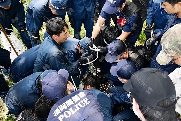 Riot police holding down a captured wild boar. Riot police and others hold down a captured wild boar at 11:53 a.m. on August 5, 2020, in Chuo ku, Fukuoka City, Japan.