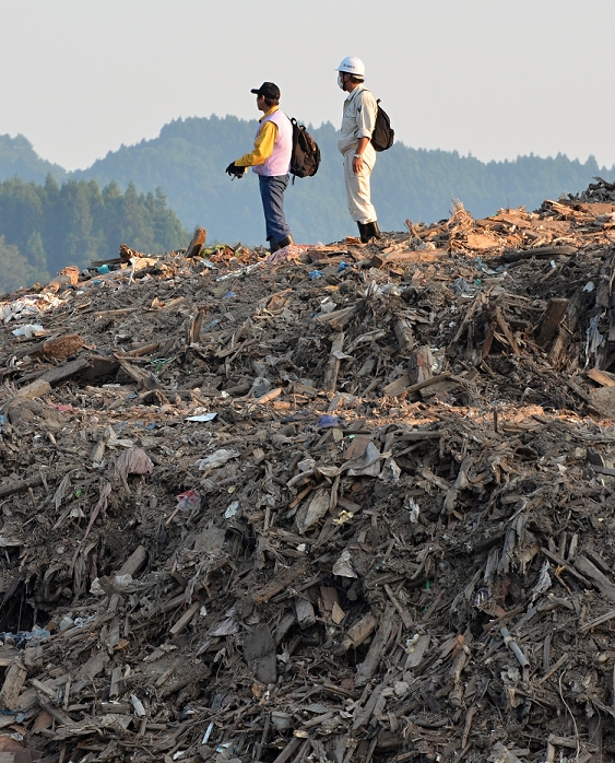 The Great East Japan Earthquake Soon six months after that day September 9, 2011, Yamada machi, Japan   Two men stand on a huge mound of debris and rubbles at a waste collection point in Yamada machi, Iwate Prefecture , some 450km northeast of Tokyo on Friday, September 9, 2011.  Nearly six months after the worst disaster Japan has ever experienced on March 11, 2011, recovery and reconstruction efforts have progressed in much of the The death toll reaches over 15,000 people with more than 4,500 people once was. The death toll reaches over 15, 000 with more than 4,500 people still missing. according to the National Police Agency.  Photo by Natsuki Sakai AFLO   3615   mis 