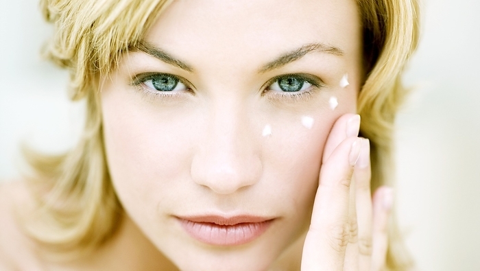 Anti wrinkle cream MODEL RELEASED. Anti wrinkle cream. Woman with dots of eye cream around her eye.