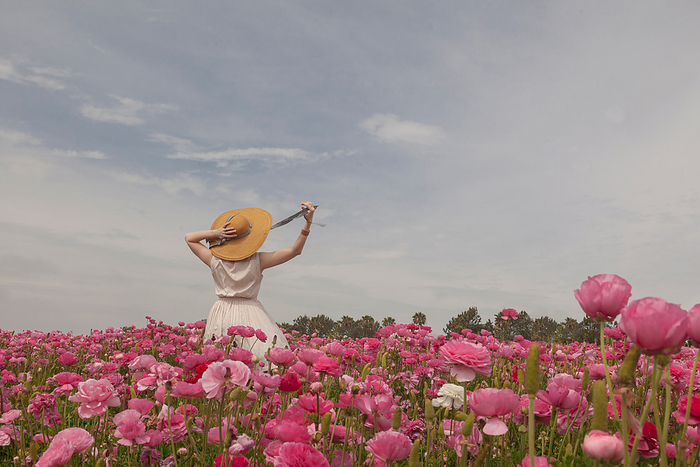 Woman in hat in field of pink flowers, San Diego, CA, United States