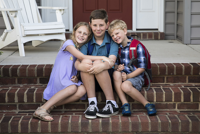 Three Smiling Siblings Sit on Brick Front Porch Steps, Easton, MD, United States