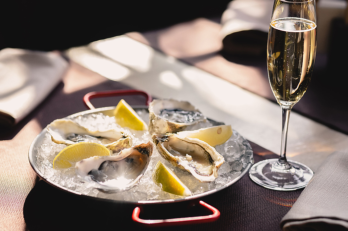 Plate with oysters, lemon and ice and a glass of champagne, Rivne, Rivne Oblast, Ukraine