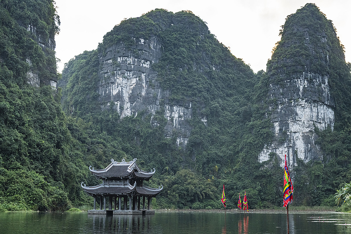 Temple standing between the limestone mountains of the Unesco site Trang An Scenic Landscape Complex, Vietnam Temple standing between the scenic limestone mountains of Trang An Landscape Complex, UNESCO World Heritage Site, Vietnam, Indochina, Southeast Asia, Asia, Photo by Michael Runkel