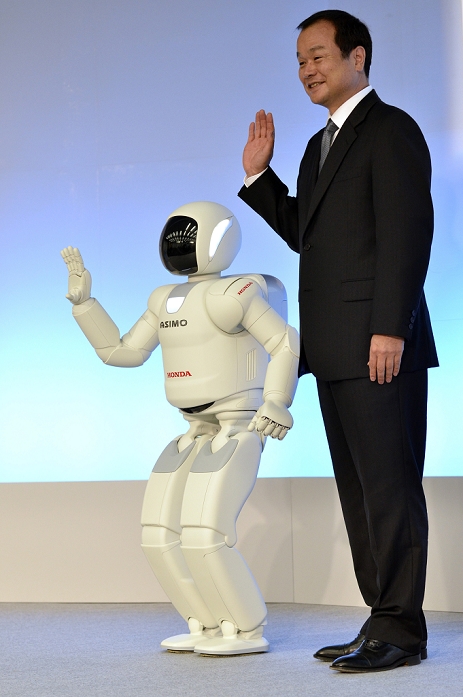 New ASIMO Announced World s First Autonomous System November 8, 2011, Wako, Japan    Asimo,  Honda s revamped human shaped robot, greets the media with President Asimo,  Honda s revamped human shaped robot, greets the media with President Takanobu Ito during a demonstration of its significantly improved intelligence and physical ability at its research facility in Wako, outside Tokyo, on Tuesday, November 8, 2011.  Asimo demonstrated its ability to walk without falling over padded bumps on the floor, run smoother and faster at 9 kilometers per hour instead of the Asimo demonstrated its ability to walk without falling overadded bumps on the floor, run smoother and faster at 9 kilometers per hour instead of the earlier 6 kph, and even distinguish the voices of three people spoken at once to figure out that one woman wanted hot coffee, another orange juice, and still another milk tea. With its improved hands, Asimo is capable of opening a thermos bottle and pouring a into a paper cup.  Photo by Natsuki Sakai AFLO   3615 .  mis 