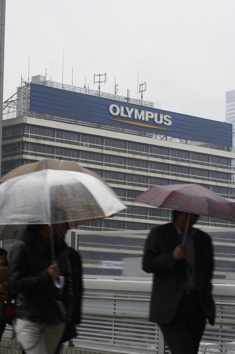 Olympus Loss Concealment Issue Tokyo Metropolitan Police Department to Conduct Full Scale Investigation November 11, 2011, Tokyo, Japan   Against the backdrop of Olympus  billboard, pedestrians scurry by in the cold mid autumn rain in Tokyo As is the weather, bleak is the company s future.  The admission of the world s biggest maker of endoscopes that it has hidden securities losses may lead to its delisting by the Tokyo Stock The admission of the world s largest manufacturer of endoscopes that it has hidden securities losses may lead to its delisting by the Tokyo Stock exchange as Japanese police have reportedly launched a full investigation into the company s concealment dating back to the 1980s. Olympus said it s likely to miss the November 14 deadline for releasing its first half earnings, prompting the TSE to place the Tokyo based Olympus shares have lost around 80 per cent of their value since the scandal broke on October 14 When the company ousted British CEO Michael Woodford, who alleged overpayments in the acquisition deals.  Photo by YUTAKA AFLO   1040   mis 
