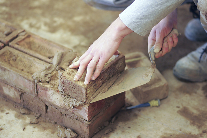 Bricklaying Construction apprentice practicing bricklaying.