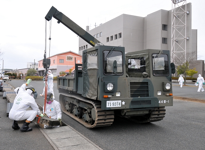 Fukushima Daiichi Nuclear Power Plant Accident Self Defense Forces decontamination of warning area December 8, 2011, Namie machi, Japan   A detail of Japan s Ground Self Defense Force launches a preparation work for a decontamination A detail of Japan s Ground Self Defense Force launches a preparation work for a decontamination operation at the Namie machi town hall in Fukushima Prefecture, some 230km northeast of Tokyo, on Thursday, December 8, 2011.  About 900 GSDF troops began cleanup operations at local government buildings in areas around the disaster hit Fukushima No. 1 nuclear power plant. The work is to prepare operational bases for full fledged cleanup that will start next year as a nuclear decontamination law goes into effect in January. They will clean up the buildings with high pressure water sprayers and metal brushes, while monitoring radiation levels. They will also scrape off the top soil with heavy machinery and shovels, according to the GSDF.  Photo by AFLO   3620   mis 