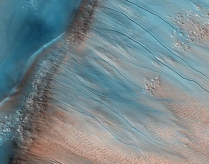 Gullies on Mars Gullies on Mars. Coloured satellite image of gullies on the wall of a crater in the South Aonia Terra region on Mars. The crater rim runs from lower left to middle top. The source of the gullies is not known. They may have been carved in the past by liquid water, or may be a result of recent landslides. The sand dune surface is rippled due to wind action. Image obtained by the High Resolution Imaging Science Experiment  HiRISE  camera on NASA s Mars Reconnaissance Orbiter  MRO  on 23rd July 2009. The width of this image is roughly 1.5 kilometres across.