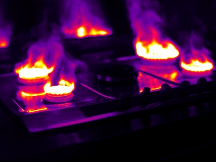 Gas stove, thermogram Gas stove. Thermogram of a gas stove with all four hobs fully lit. Thermography records surface temperatures by detecting the long wavelength radiation emitted by an object. Here, the colour coded temperature scale runs from white  warmest  through yellow, red and purple to black  coldest .