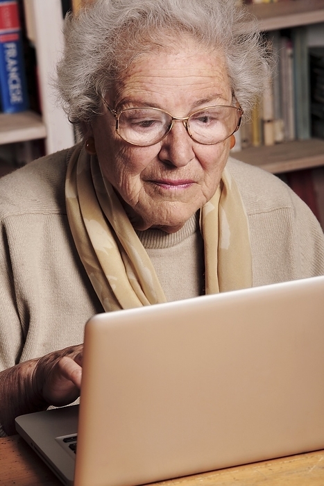 Elderly lady using a laptop MODEL RELEASED. Elderly lady using a laptop computer.