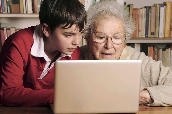 Elderly lady learning to use a laptop MODEL RELEASED. Elderly lady learning to use a laptop.