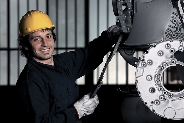 Motor vehicle parts Motor vehicle parts. Worker handling an assortment of moulded plastic motor vehicle parts.