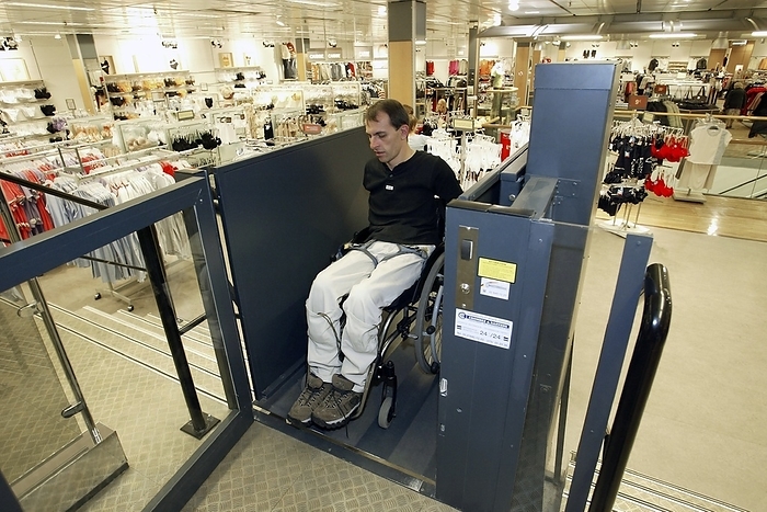 Wheelchair user Wheelchair user. Man using a wheelchair lift in a shop.
