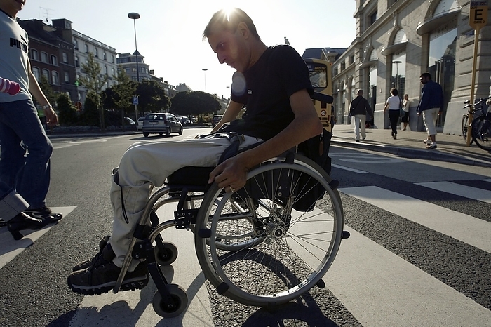 Wheelchair user Wheelchair user crossing a street.