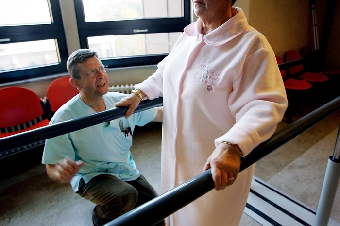 Rehabilitation therapy Rehabilitation. Physiotherapist working with a patient that has recently had surgery.