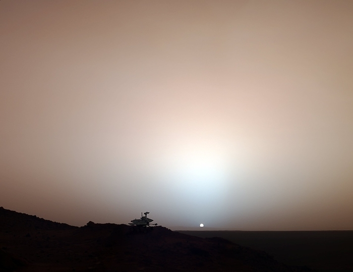 Martian sunset, composite image Martian sunset. Composite image of the Sun setting on the Mars exploration rover Spirit  left . There is a bluish glow in the sky around and above the Sun. Such glows can remain visible for up to 2 hours after sunset or before sunrise. The glow is caused by high altitude dust scattering sunlight around to the night side of the planet. The rest of the sky is reddish due to the large amount of dust in the atmosphere. This is a composite image, with a model of Spirit added to an image the rover took on its 489th Martian day, 19 May 2005.