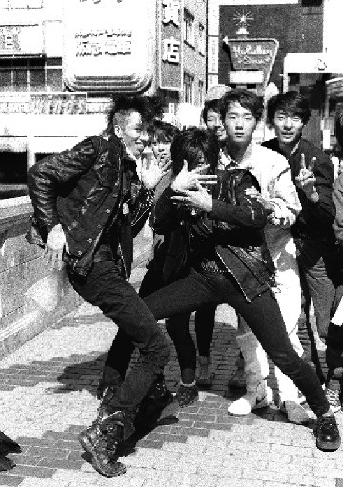 Punk Fashion (February 7, 1985): Young people following the outfits of punk rock musicians from London, with their hair cut in Mohawks, T-shirts with holes in them, spiky leather jumpers with bows, slim pants, sturdy shoes with lead in them, and chains all over the place. On the Ebisu Bridge in Shinsaibashi, Minami Ward, Osaka City.