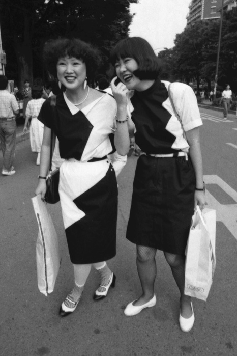 Harajuku Culture  Taken in June 1980  Young people dressed in fashionable monotone  black and white color scheme   around June 1980 : The topic of the summer of 1980 was the monotone  black and white  craze. It was a worldwide trend and was overwhelmingly popular in Harajuku. The two people in the photo are already anticipating the fall and winter trends. In addition to the black and white color scheme, their clothes are asymmetrical and asymmetrical.