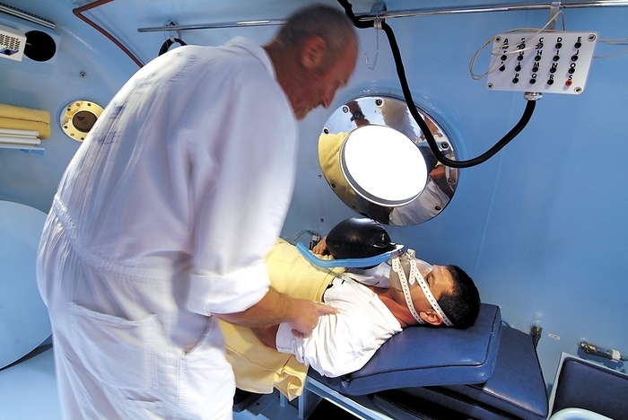 Hyperbaric chamber in a hospital Hyperbaric chamber in a hospital. Patient being prepared for treatment in a hyperbaric chamber. Hyperbaric chambers are capable of holding patients for long periods in a high pressure environment. In hospitals they are used for recompression treatment of SCUBA divers suffering from decompression sickness, and also in hyperbaric therapy to treat certain conditions such as carbon monoxide poisoning and embolisms. Photographed in Nice, France.