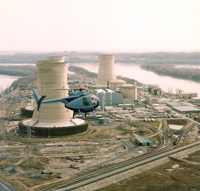 Three Mile Island incident, 1979 Three Mile Island incident. H 500 helicopter over Three Mile Island  TMI  nuclear power station near Harrisburg, Pennsylvania, USA, on 30 April 1979. An accident at TMI Unit 2 on 28 March 1979 led to a nuclear incident. It was caused by a loss of reactor cooling water that resulted in the exposure of fuel rods, some of which melted, burned through the reactor chamber lining and sank to the floor of the reactor building. The clean up operation took 14 years. From a set of photographs taken for the President s Commission on the accident.