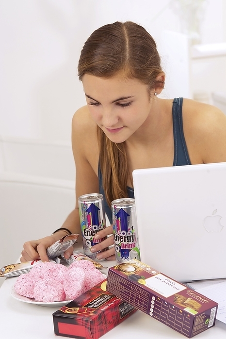 Student eating sugary snacks Teenage female student eating sugary snacks and energy drinks while studying using a laptop computer. Processed foods that are high in sugars provide a temporary energy boost. However, this is less healthy than eating foods containing more complex carbohydrates that take longer to be digested and provide a slower release of energy. Energy drinks can contain sugars along with caffeine or other stimulants. Excessive consumption of energy drinks can lead to agitation and insomnia.