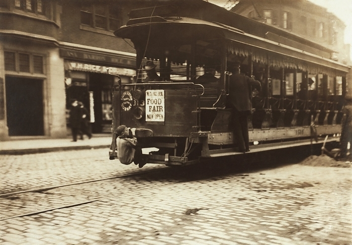 Child riding on a tram, Boston, 1909 Child riding on a tram in the streets of Boston, Massachusetts, USA, 1909. This illegal practice, where children rode on the rear of trams, was known as  flipping cars . By this period, trams  also called streetcars  ran on electricity, with the conversion from horse drawn vehicles taking place in the 1880s and 1890s. This urban street scene, obtained by US sociologist and photographer Lewis Wickes Hine  1874 1940 , dates from October 1909. Hine was a photographer for the National Child Labor Committee  NCLC , documenting working and living conditions for children, and campaigning against child labour and poverty in the USA.