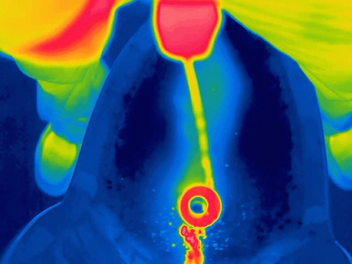 Man urinating, thermogram Man urinating. Thermogram of a man urinating into a urinal. The colours show variation in temperature. The scale runs from black  coldest  through purple, pink, red, orange and yellow, to white  warmest . Thermography records the temperature of objects by detecting long  wavelength radiation.