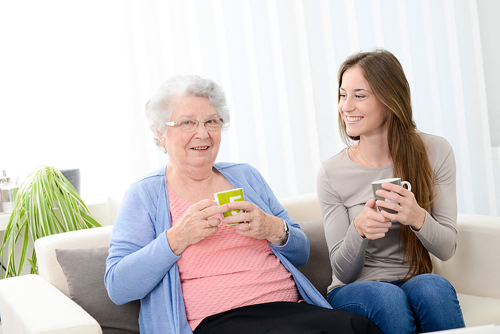 femme senior prennant le th  avec une charmante jeune fille a la maison conversation partage   happy old senior woman spending time drinking tea with cheerful young girl at home Happy old senior woman spending time drinking tea with cheerful young girl at home
