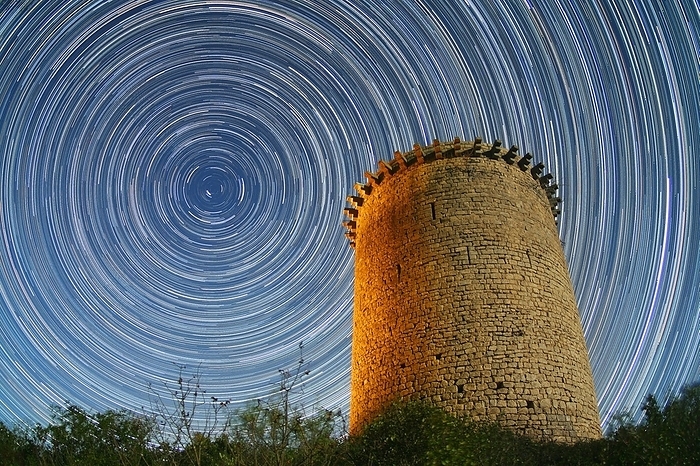 Polar star trails over tower Polar star trails over tower. Time exposure image of star trails around the northern celestial pole, over the 12th century watchtower at Sant Llorenc de la Muga, Girona, Spain.