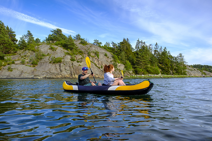 Sweden, Vastra Gotaland County, Kyrkesund, People kayaking near coast of Lilla Askeron island