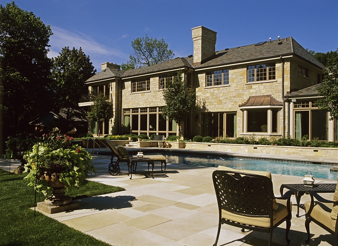 Swimming Pool: Traditional upscale Limestone two story home, slate roof.  Large rectangular pool and patio area.  Limestone and tile used on pool.  Large urn planter on left.