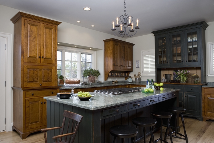 KITCHEN: Modern country , custom  furniture style cabinets in a period style, dark green and warm maple stain, green granite counters, cooktop in center island, cake stand, candle chandelier