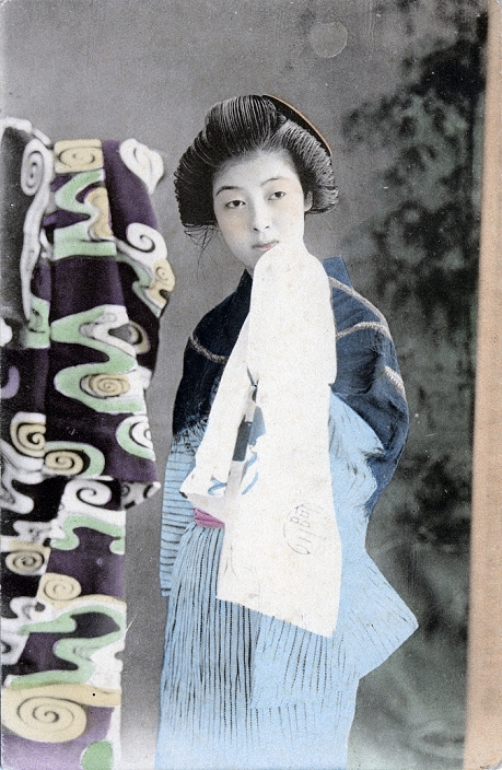 Woman in Kimono  unknown date  Young Japanese woman in kimono and traditional hairdo, holding a bath towel.