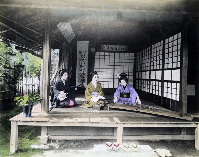 Woman in Kimono  Date unknown  Young Japanese women in kimono and traditional hairdo are performing music in a traditional Japanese room with an engawa, a veranda like extension of the house. One women is playing the koto  right , another the shamisen  left , while the woman in the middle is holding a book of songs. Geta are neatly arranged on the kutsunugi ishi, a stone for leaving the shoes. Part of the garden is visible.