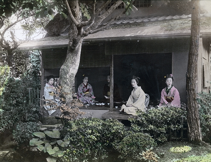 Woman in Kimono  Date unknown  Five women in kimono and traditional hairstyles are having tea in a cottage with thatched roof and Japanese garden. Two are sitting on the engawa  porch .