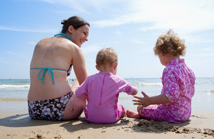 Mother playing on beach with girls