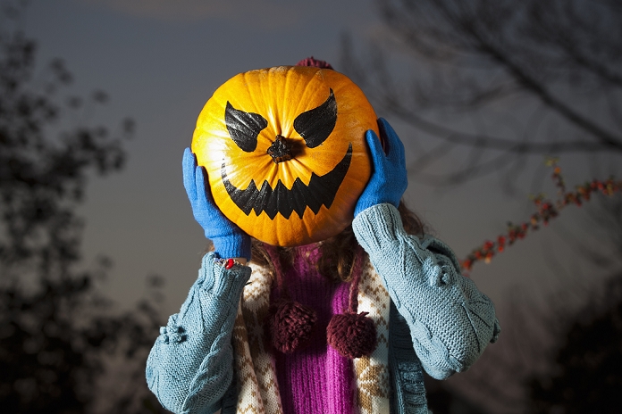 Halloween Woman holding jack oi lantern over face
