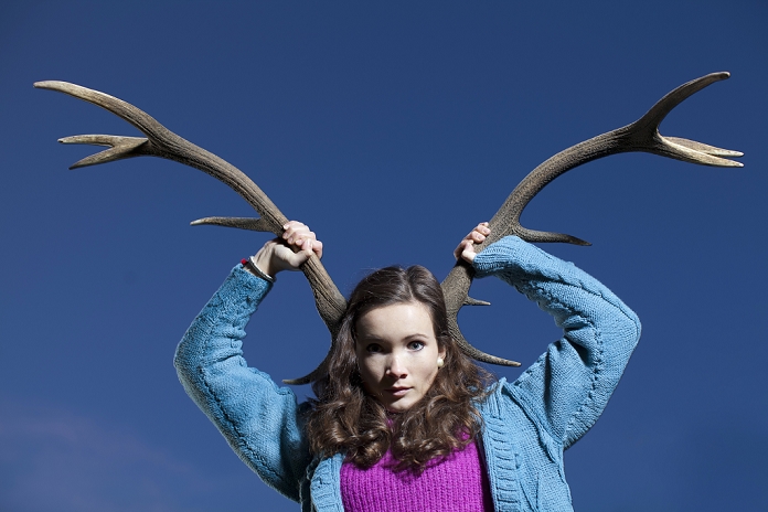 Woman holding antlers on head