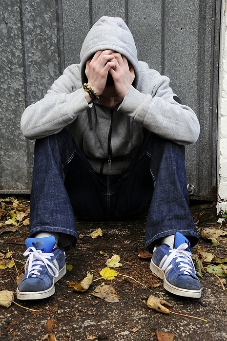 Depressed teenager Depressed teenager. 18 year old depressed teenage boy resting his head in his hands.