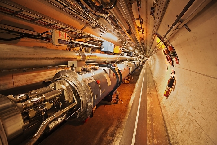 Large Hadron Collider tunnel A section of the 27Km circular tunnel beneath the French Swiss border near Geneva. The tunnel carries the Large Hadron Collider particle accelerator which houses two beams of protons, within separate high vacuum pipes, traveling in opposite directions, kept on an accurate path by dipole super  Photographed during the 2013 shutdown, with the Photographed during the 2013 shutdown, with the main vacuum pipe open for maintenance work.