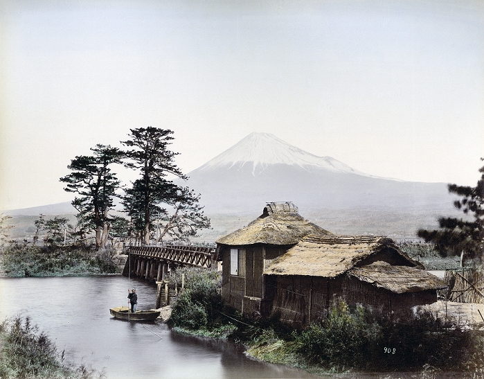 Mt. Fuji  1880s  Kawaibashi Bridge spanning the Numakawa River near Taganoura on the Tokaido, ca. 1880s. In the foreground is a building with a thatched roof, next to it is a small wharf where a man is standing in a small wooden boat. In the background Mt. Fuji can be seen. The Numakawa flows from Ukishima Pond towards Tagonoura. Before the bridge was built during the Kanbun Era  1661 1673 , people crossed this location by ferry. Across the bridge electricity poles can be seen, indicating that this photo was taken during the 1880s.